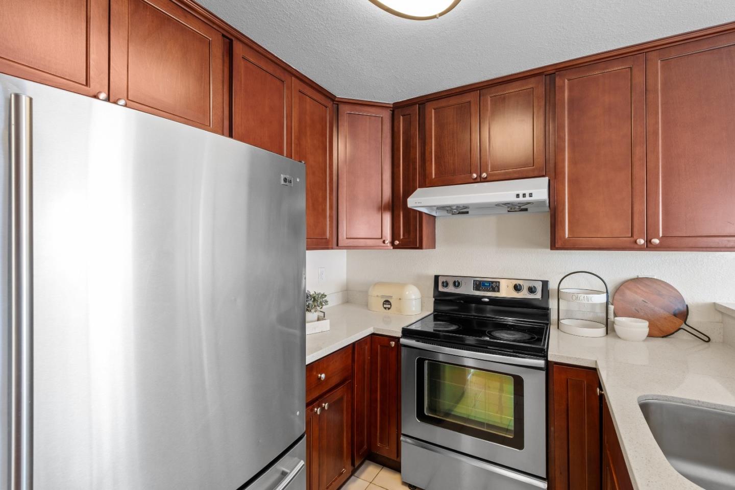 1392 Meadow Ridge Circle San Jose, CA 95131 - Photo 14 of 43 a kitchen with stainless steel appliances a stove a microwave and cabinets