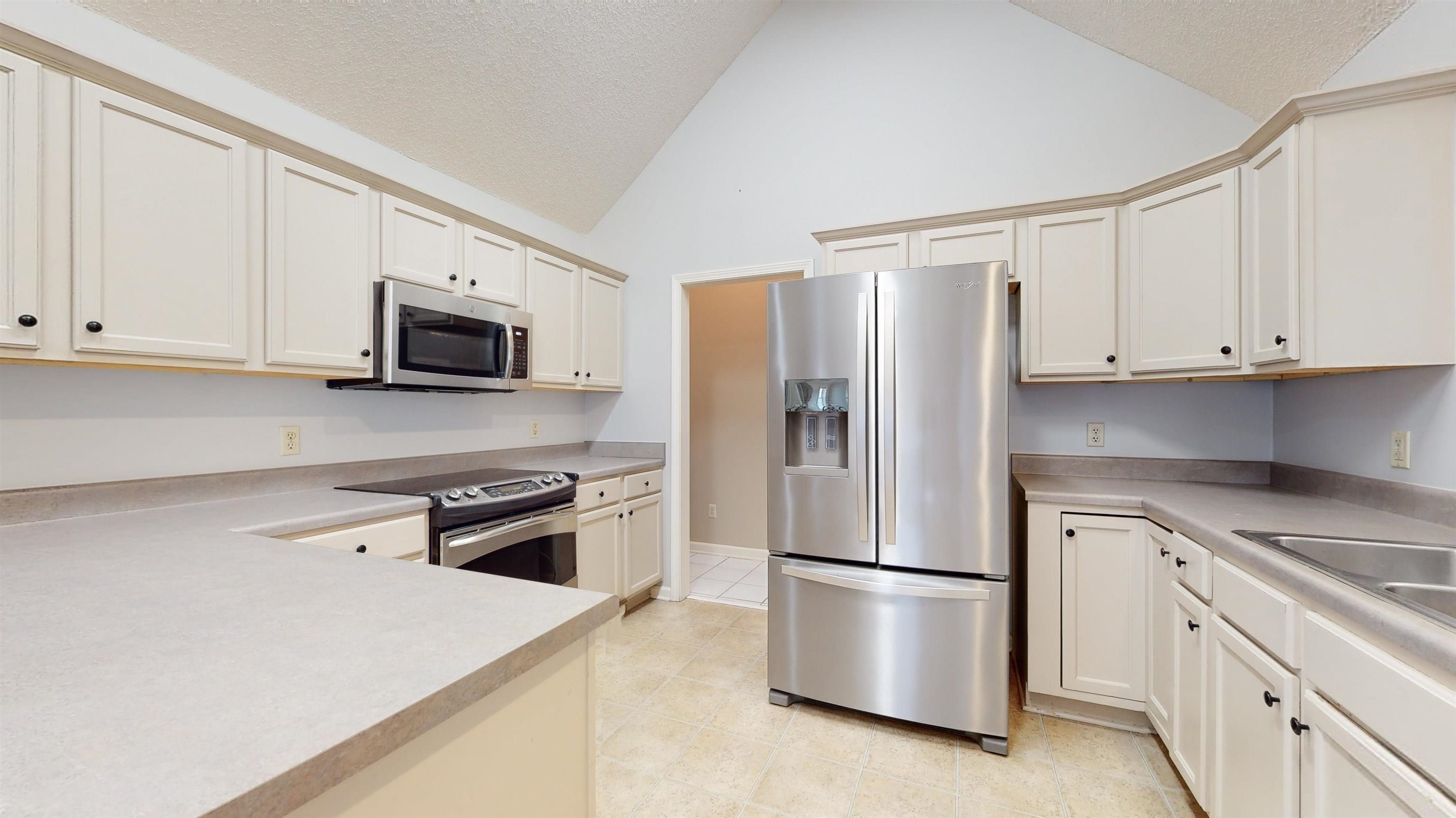 195 Cross Point Drive Collierville, TN 38017 - Photo 2 of 11 a kitchen with stainless steel appliances white cabinets and a refrigerator