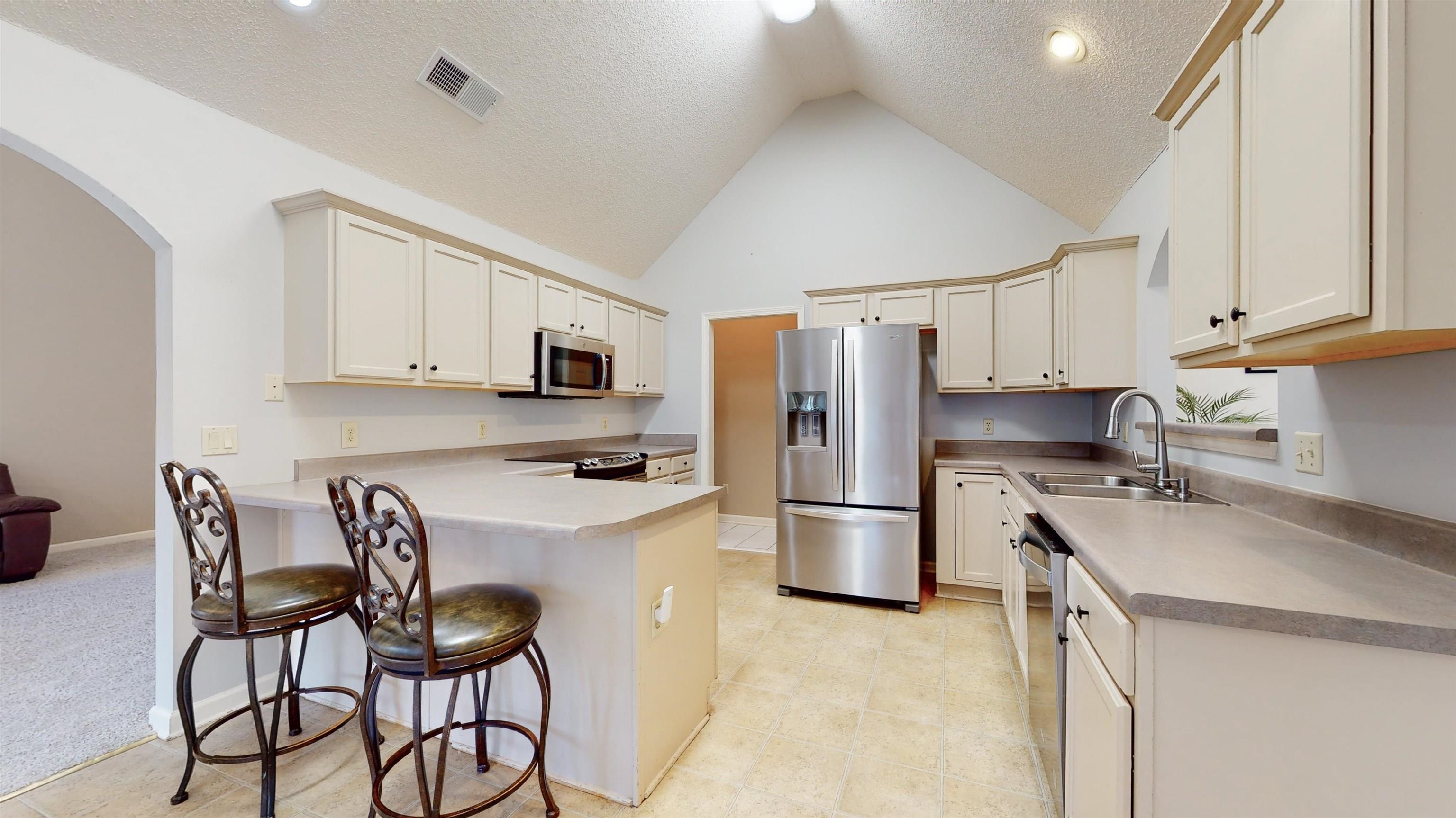 195 Cross Point Drive Collierville, TN 38017 - Photo 3 of 11 a kitchen with stainless steel appliances a refrigerator stove microwave and white cabinets