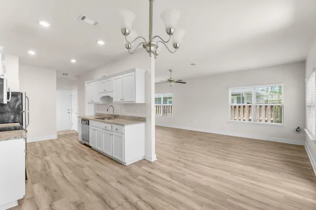 a large kitchen with granite countertop a large counter top a sink stainless steel appliances and cabinets