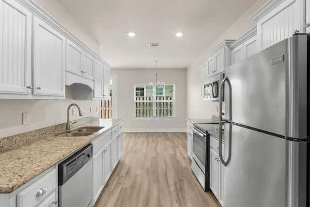 a kitchen with stainless steel appliances granite countertop a sink stove and refrigerator