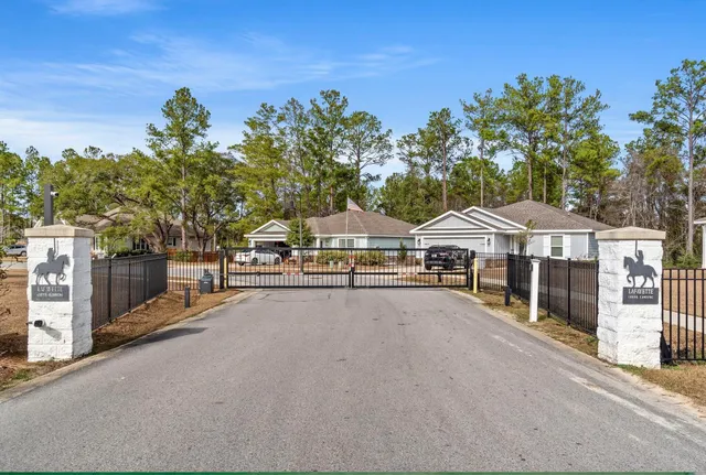 a view of a white house with a big yard and large trees