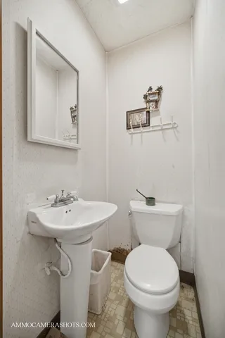 a bathroom with a toilet sink and mirror