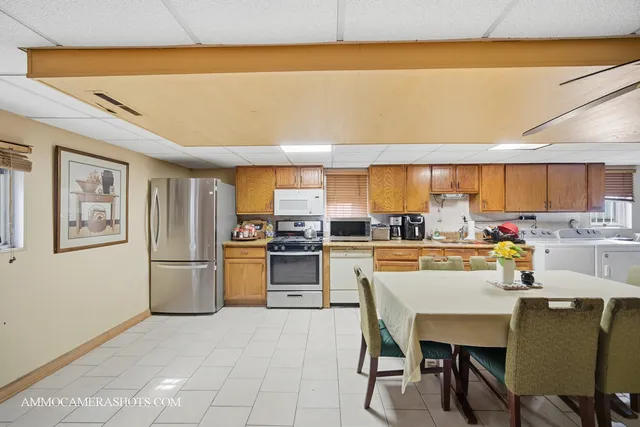 a kitchen with a refrigerator a stove a sink and white cabinets with wooden floor