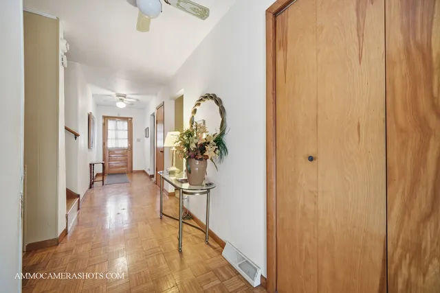 a view of a hallway with wooden floor and furniture
