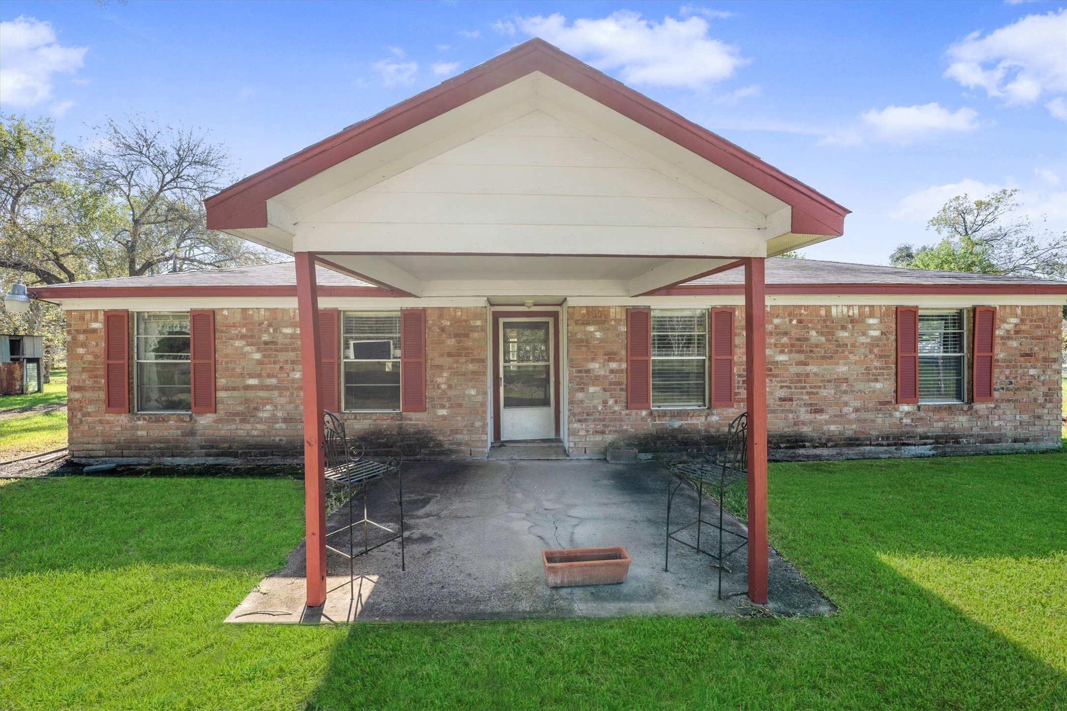 Peaceful country charm welcomes you home with wide open green space, towering shade trees, and a classic brick exterior that feels timeless.