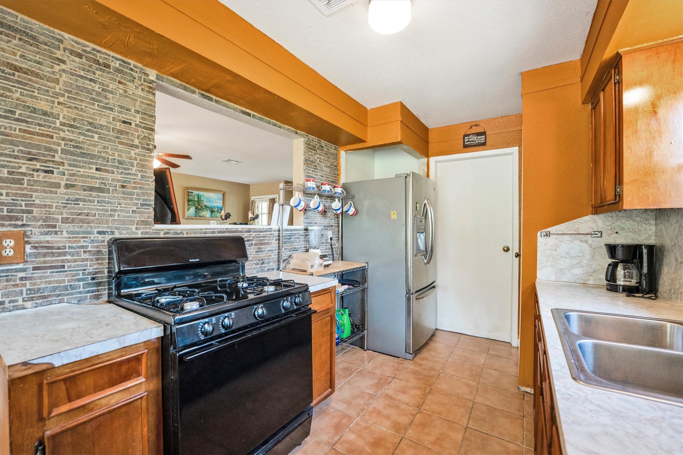 18111 Roy Long Road Pearland, TX 77584 - Photo 13 of 36 This charming kitchen offers plenty of counter space, rich wood cabinetry, and a beautiful brick accent wall that adds warmth and texture.