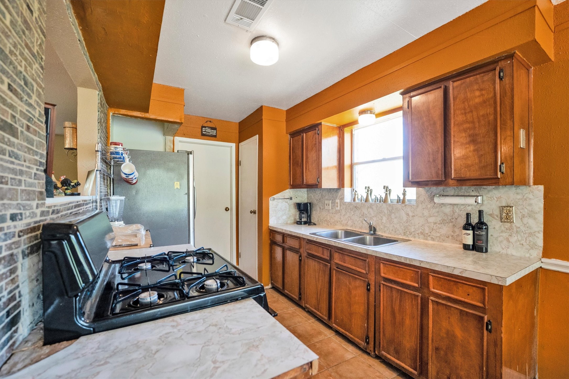 18111 Roy Long Road Pearland, TX 77584 - Photo 14 of 36 Natural light pours in through the window, highlighting the functional layout and cheerful color palette that makes this space a joy to cook in.