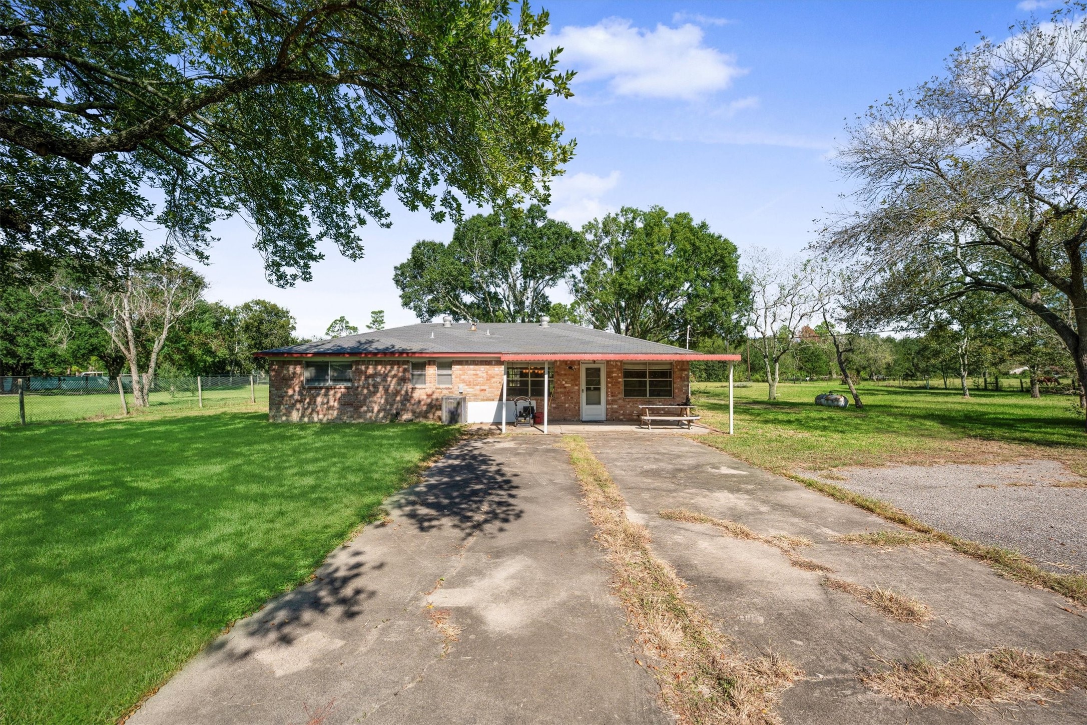 18111 Roy Long Road Pearland, TX 77584 - Photo 29 of 36 Ample paved space for parking or projects, paired with open grassy areas perfect for gatherings or play.
