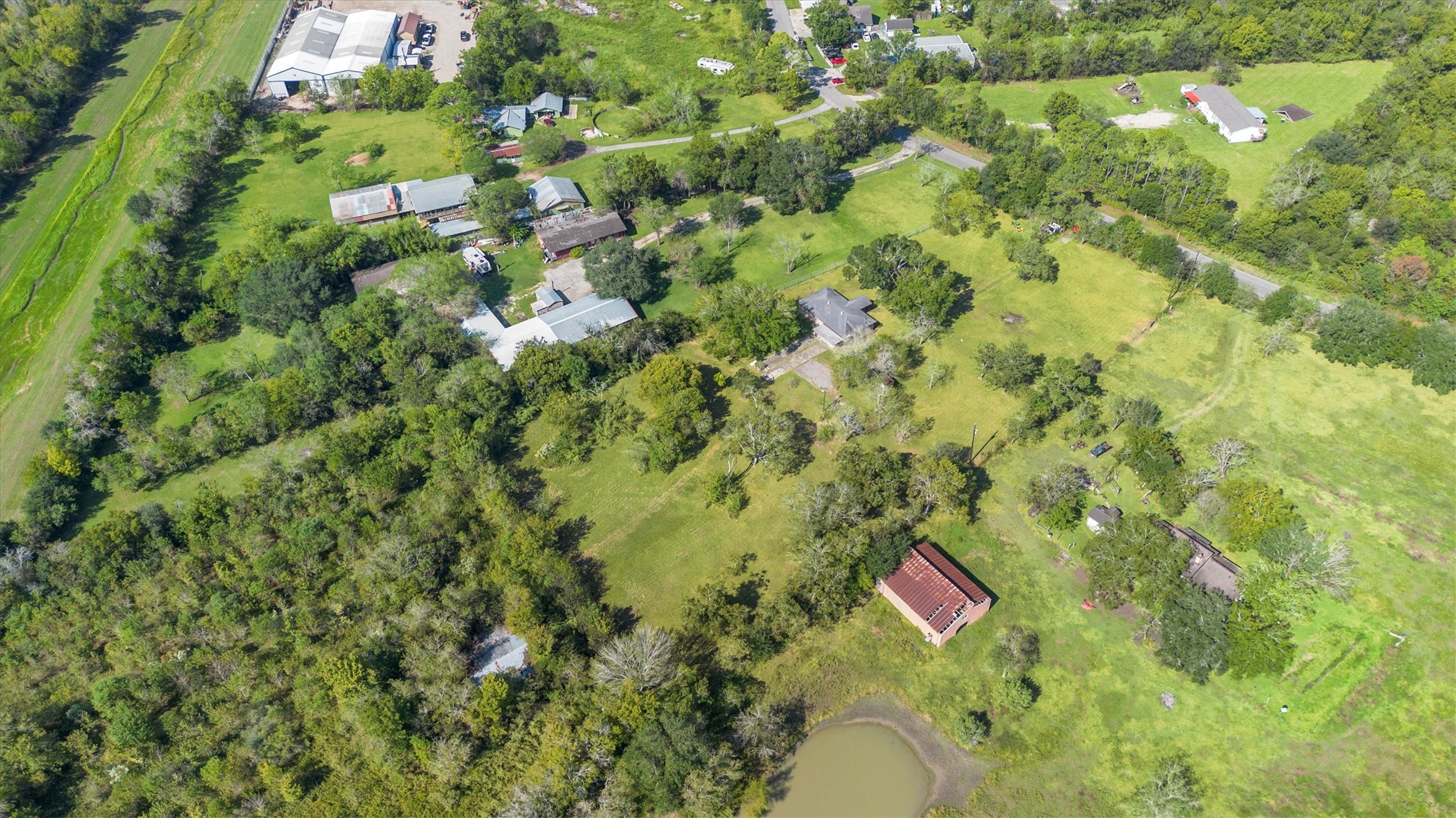 18111 Roy Long Road Pearland, TX 77584 - Photo 36 of 36 The aerial view showcases the property’s beautiful natural surroundings, with open green space, mature trees, and a peaceful rural backdrop that enhances the sense of privacy and tranquility.