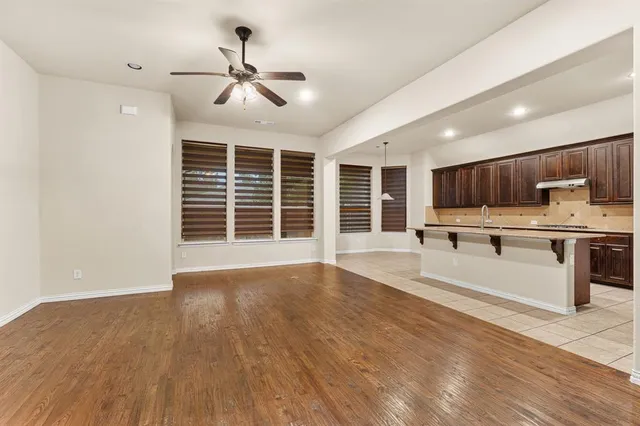 a view of kitchen with stainless steel appliances wooden floor and large window