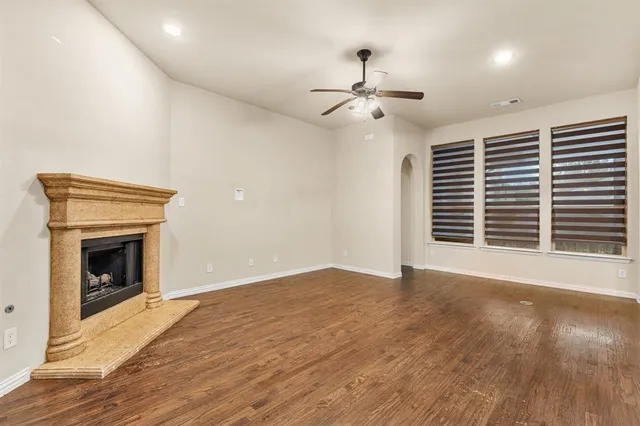 a view of empty room with wooden floor and fireplace
