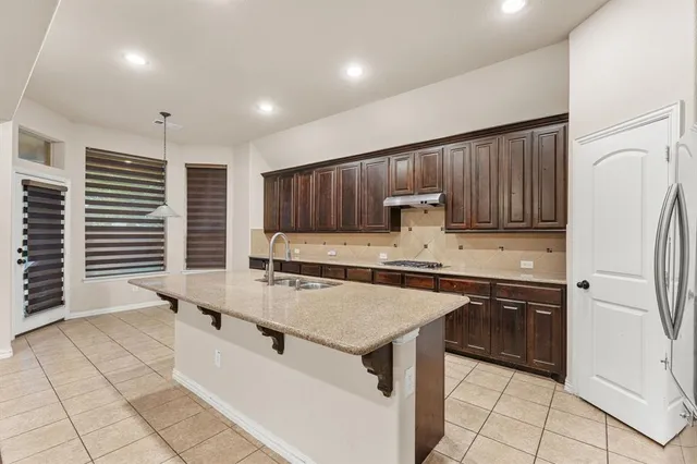 a kitchen with stainless steel appliances a stove a sink a refrigerator and cabinets