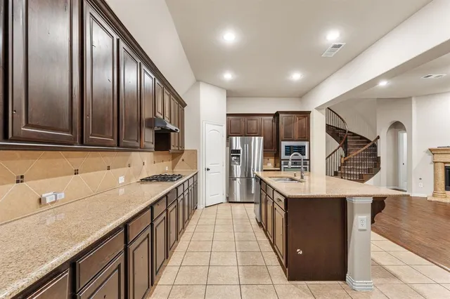 a kitchen with stainless steel appliances granite countertop counter top space a sink wooden cabinets and granite counter tops