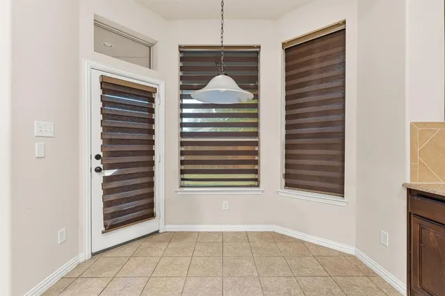 a view of an empty room with a fireplace and a window