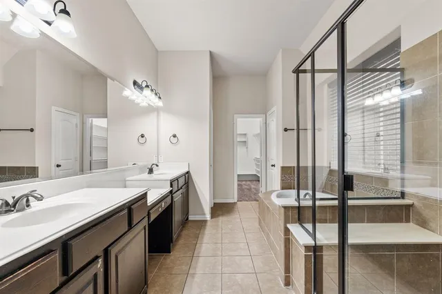 a spacious bathroom with a double vanity sink a mirror and a bathtub