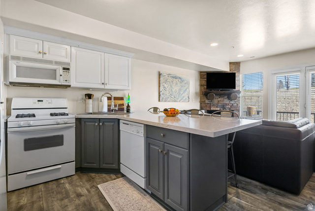3598 North Huntsman Path, Unit 502 Eden, UT 84310 - Photo 43 of 43 Dual tone kitchen with a kitchen bar, dual tone cabinets, white appliances, open floor plan, and a peninsula