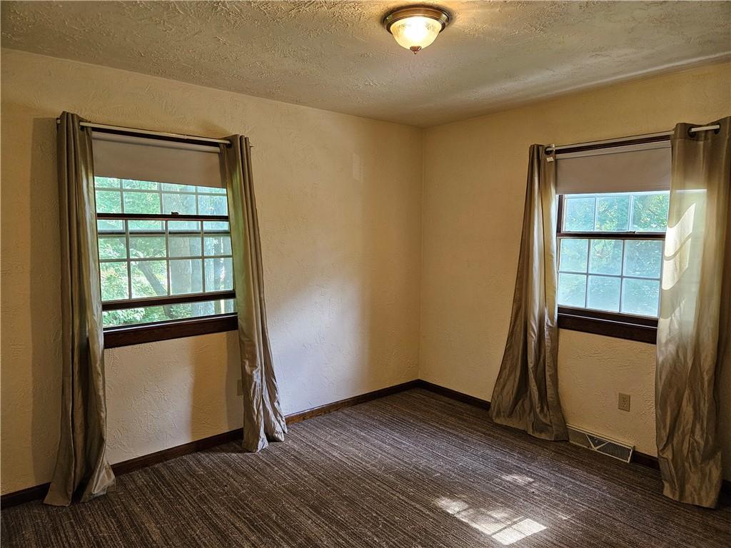 207 College Lodge Road Indiana, PA 15701 - Photo 21 of 36 an empty room with wooden floor cabinet and windows