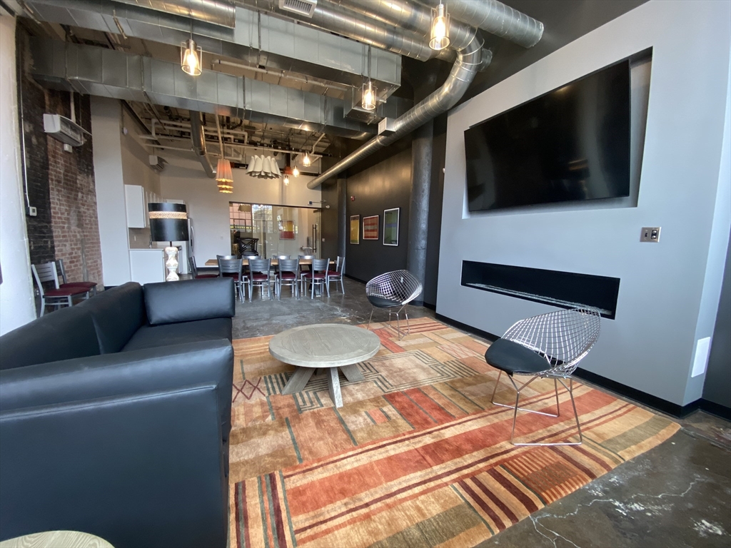 151 Chestnut Street, Unit 413 Springfield, MA 01103 - Photo 7 of 11 a living room with furniture and a flat screen tv