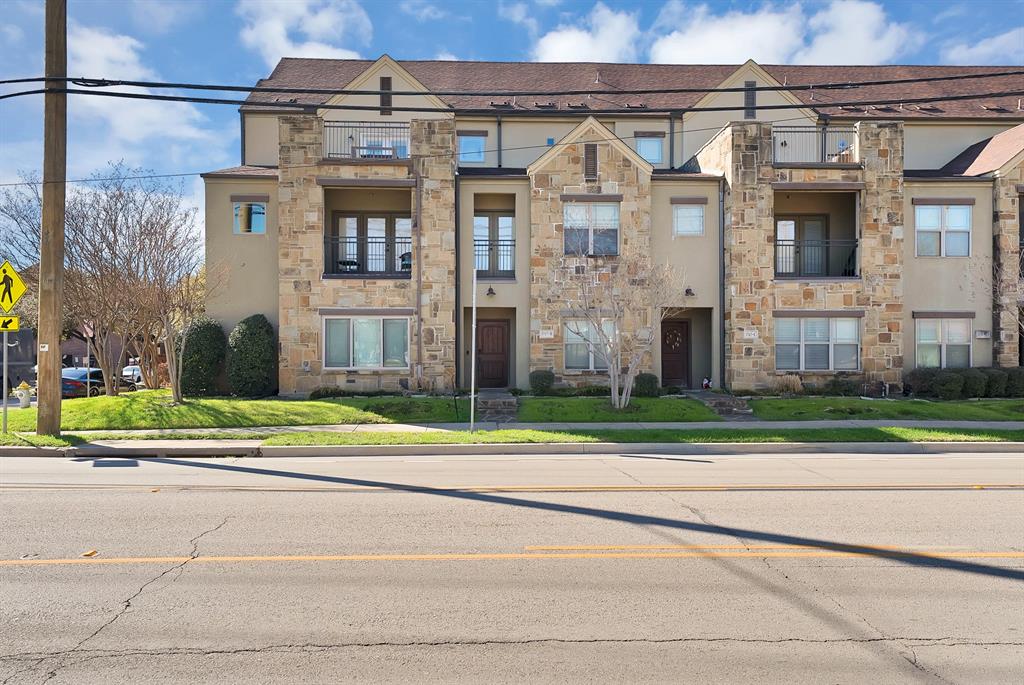 a view of a brick house next to a yard
