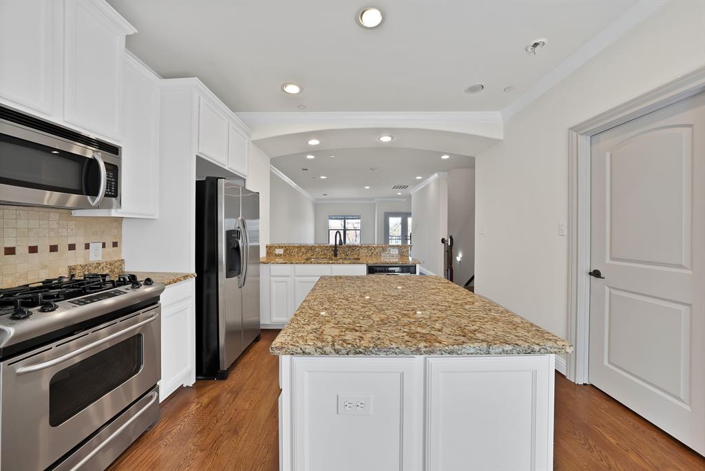 5747 Prospect Avenue, Unit B Dallas, TX 75206 - Photo 13 of 40 a kitchen with stainless steel appliances kitchen island granite countertop a stove and a refrigerator