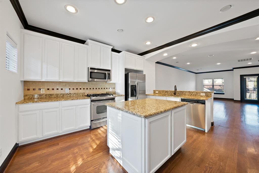 5747 Prospect Avenue, Unit B Dallas, TX 75206 - Photo 17 of 39 a kitchen with stainless steel appliances granite countertop a stove top oven a sink and a refrigerator