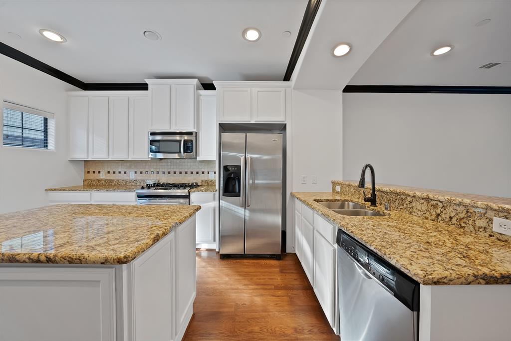 5747 Prospect Avenue, Unit B Dallas, TX 75206 - Photo 20 of 39 a kitchen with kitchen island granite countertop a sink and refrigerator