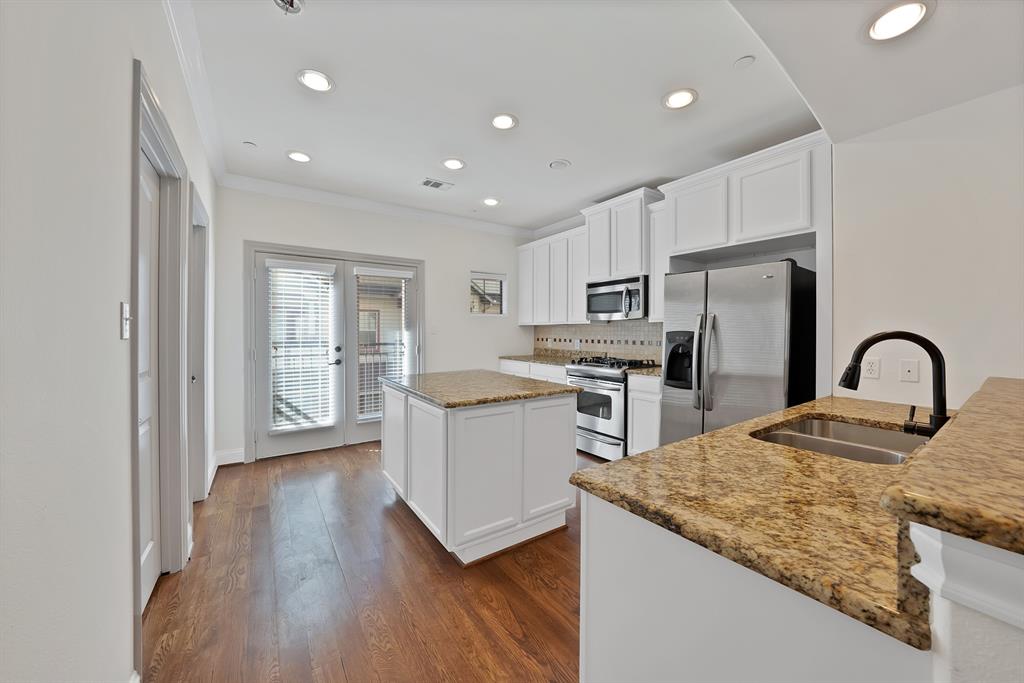 5747 Prospect Avenue, Unit B Dallas, TX 75206 - Photo 10 of 40 a kitchen with refrigerator cabinets and wooden floor