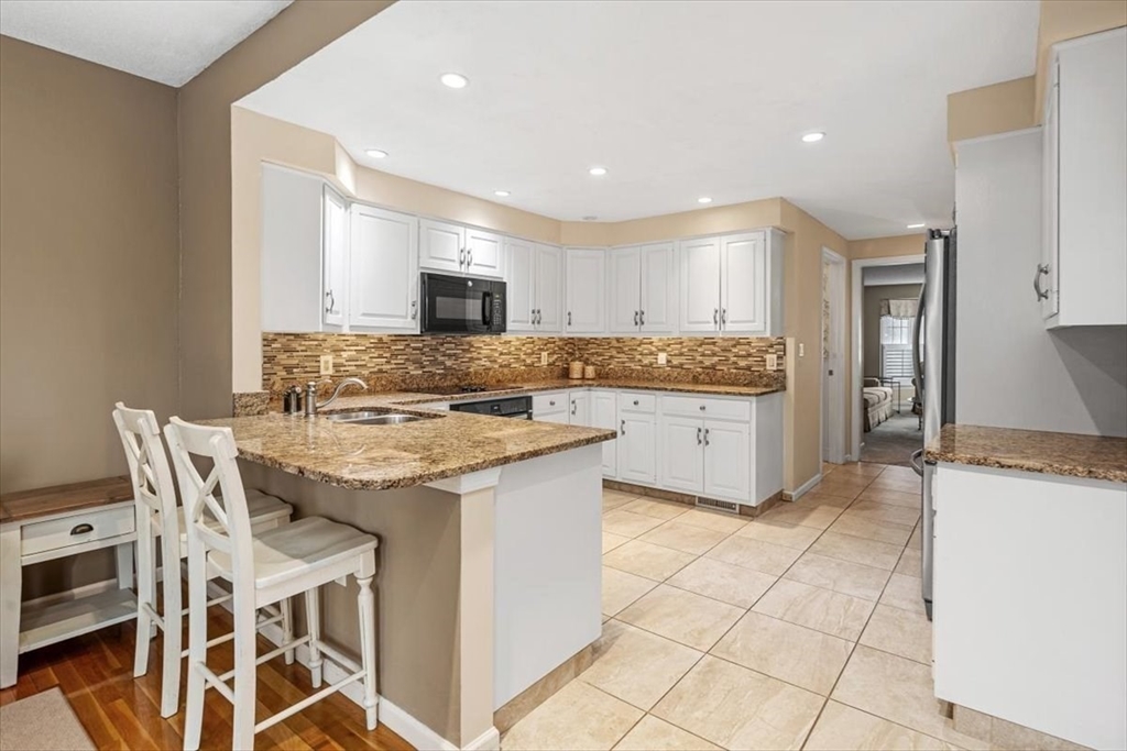 74 Thistle Patch Way, Unit 74 Hingham, MA 02043 - Photo 5 of 22 a kitchen with granite countertop cabinets and chair