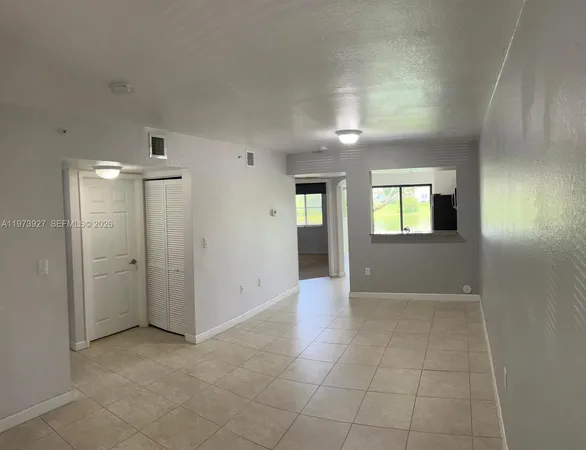 an empty room with entrance and windows