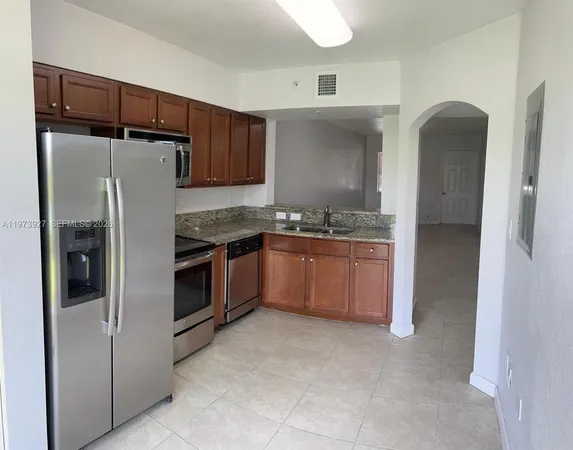 a kitchen with stainless steel appliances granite countertop a refrigerator and a stove