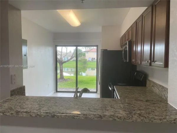 a view of an empty room with a fireplace and windows