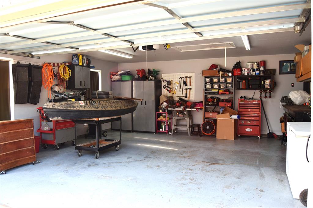 605 Jade Haughton, LA 71037 - Photo 22 of 34 Spacious garage featuring a light gray concrete floor,overhead fluorescent lighting,wood colored cabinets will stay and single garage doors