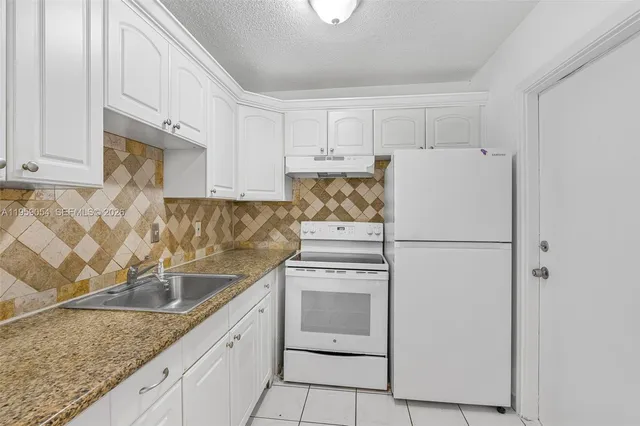 a kitchen with white cabinets and white appliances
