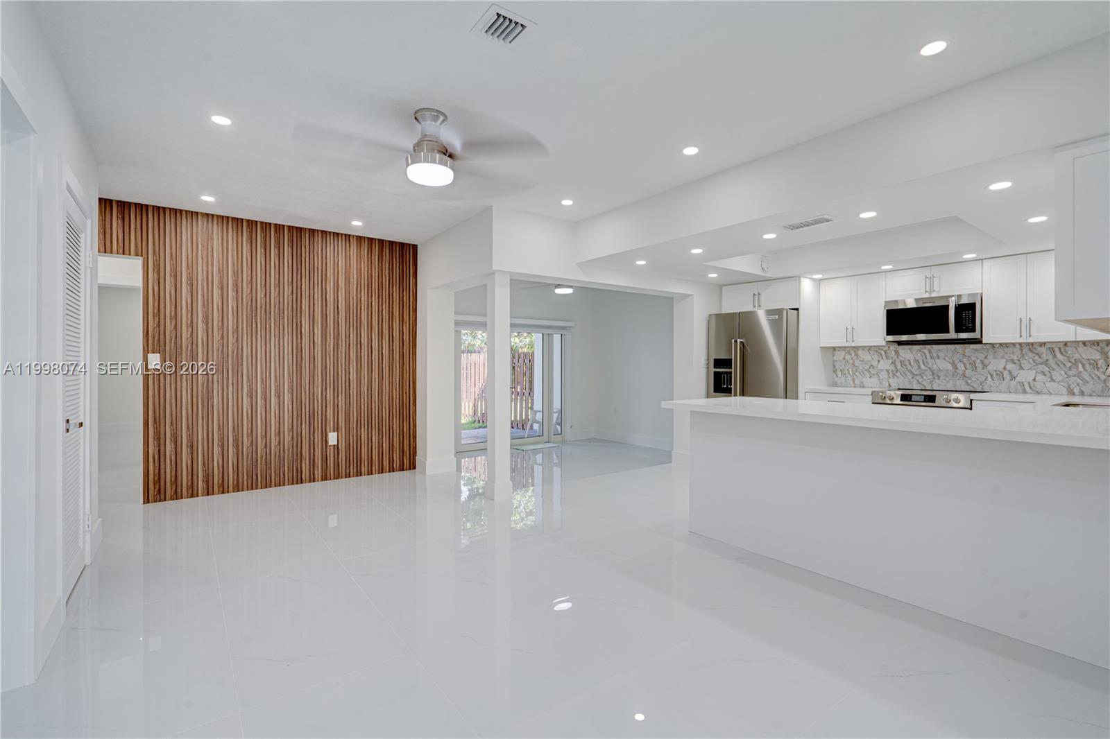 Pinecrest Pinecrest, FL 33156 - Photo 5 of 9 a large white kitchen with stainless steel appliances kitchen island a large island in the center
