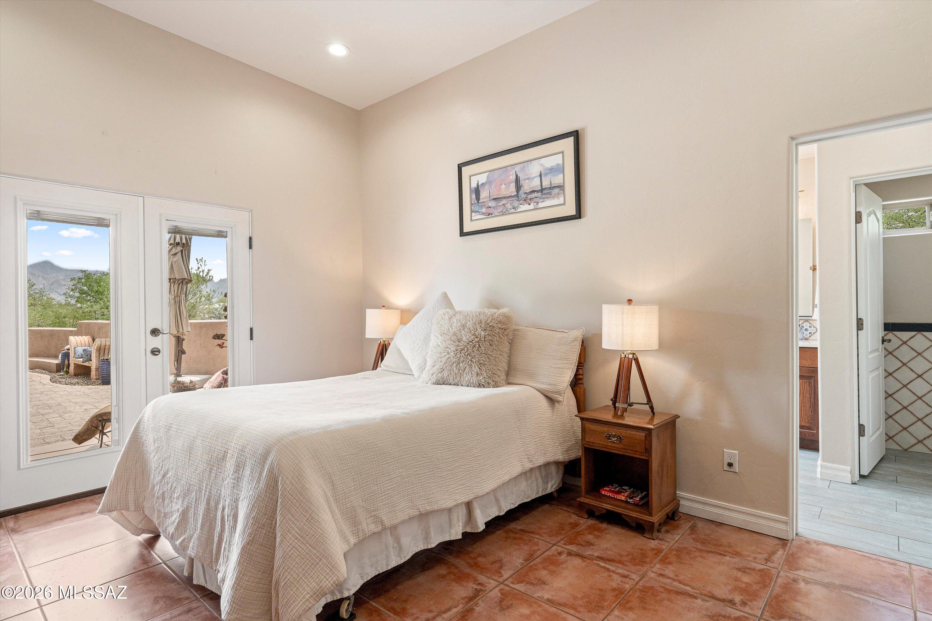 4760 East Wagon Train Road Tucson, AZ 85739 - Photo 19 of 38 a bedroom with a bed and lamp