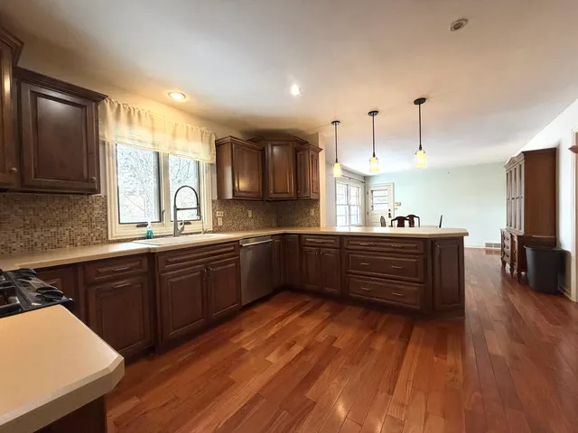 a kitchen with stainless steel appliances kitchen island granite countertop a stove a sink and a microwave
