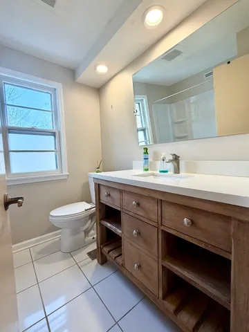 a bathroom with a toilet a sink and mirror