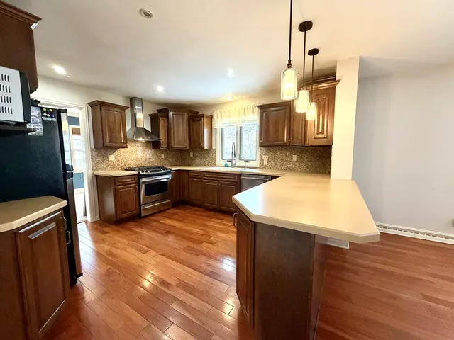 a kitchen with stainless steel appliances granite countertop a sink a stove and a refrigerator