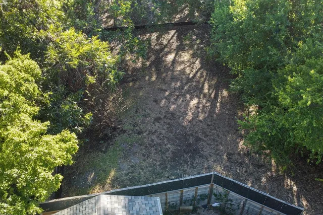 a side view of a house with a tree