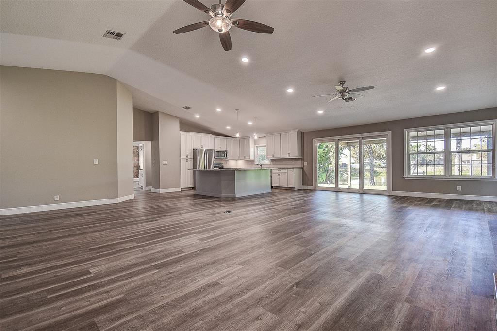 289 Whisper Lake Road Palm Harbor, FL 34683 - Photo 13 of 40 an empty room with wooden floor and windows