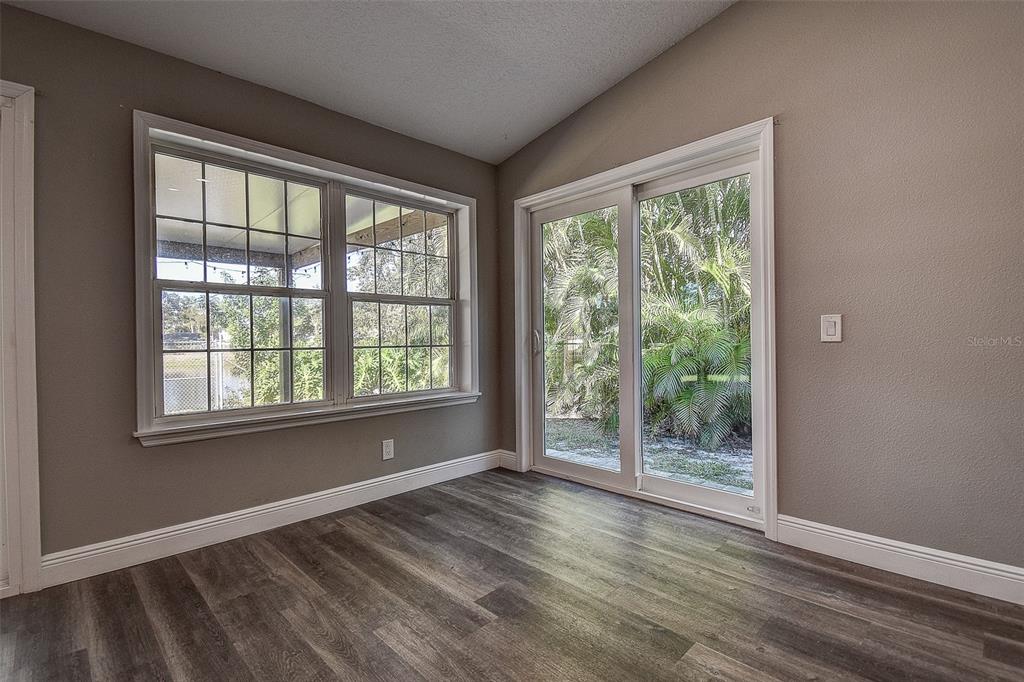 289 Whisper Lake Road Palm Harbor, FL 34683 - Photo 14 of 40 a view of an empty room with wooden floor and a window