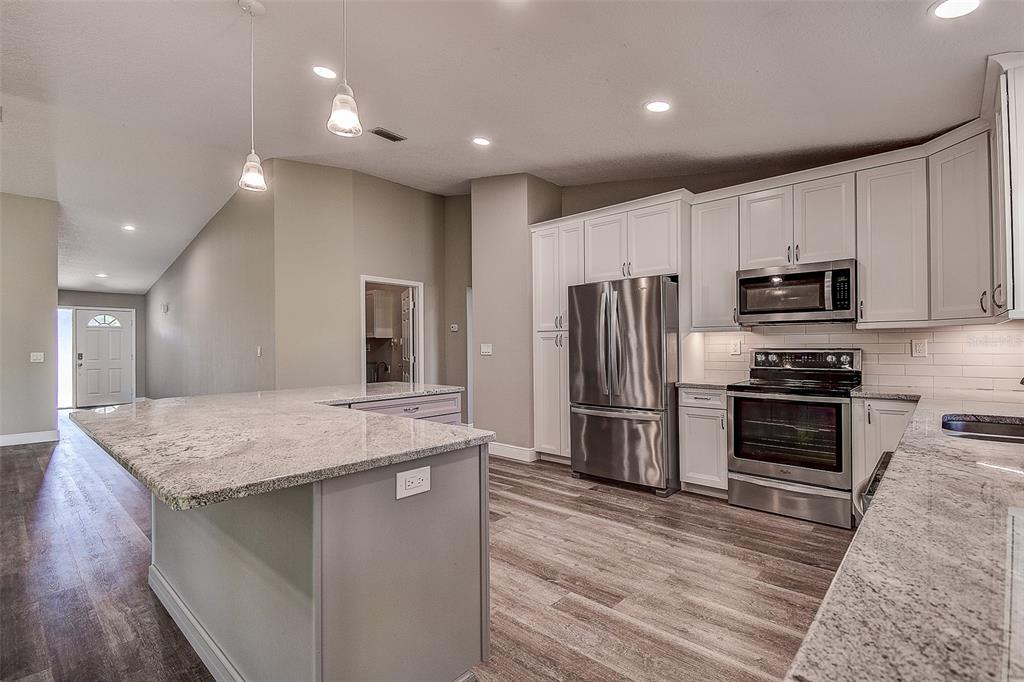 289 Whisper Lake Road Palm Harbor, FL 34683 - Photo 17 of 40 a kitchen with kitchen island a sink stainless steel appliances and counter space