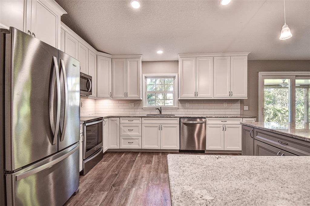 289 Whisper Lake Road Palm Harbor, FL 34683 - Photo 20 of 40 a kitchen with stainless steel appliances granite countertop a refrigerator sink and stove