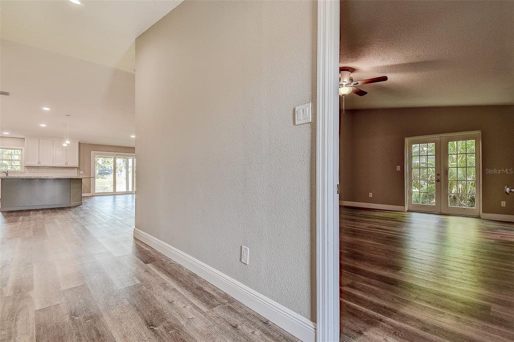 289 Whisper Lake Road Palm Harbor, FL 34683 - Photo 4 of 40 a view of a hallway with wooden floor and a kitchen