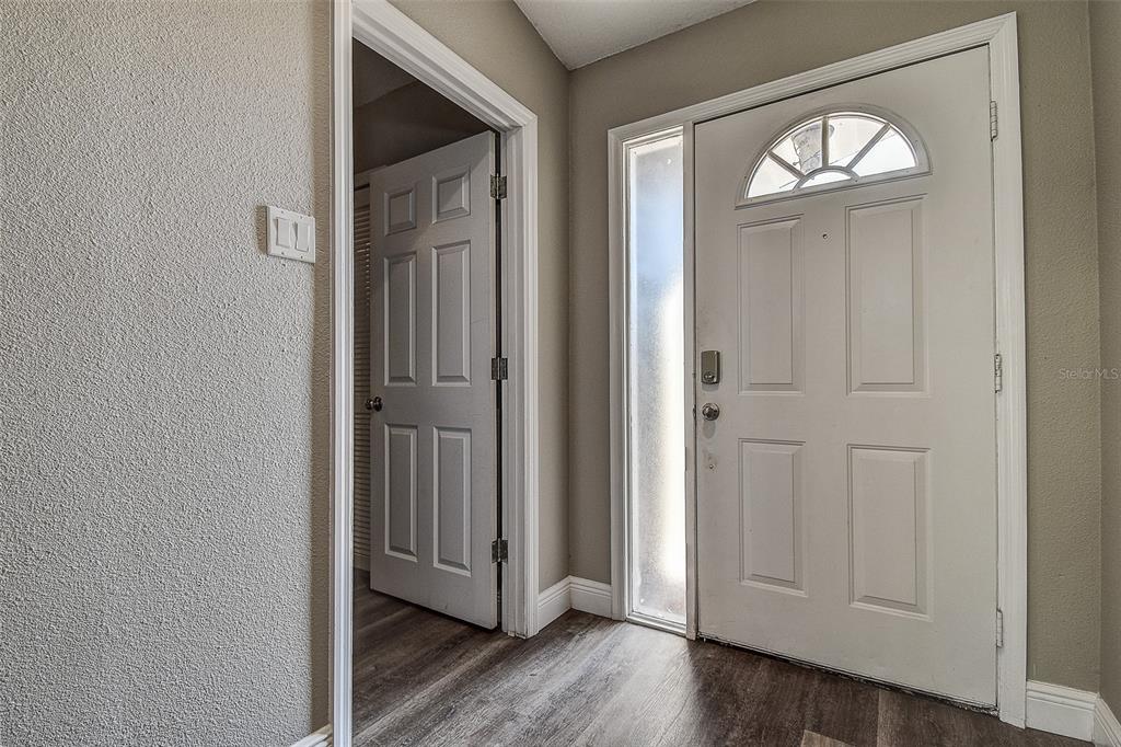 289 Whisper Lake Road Palm Harbor, FL 34683 - Photo 5 of 40 an empty room with wooden floor mirror and door
