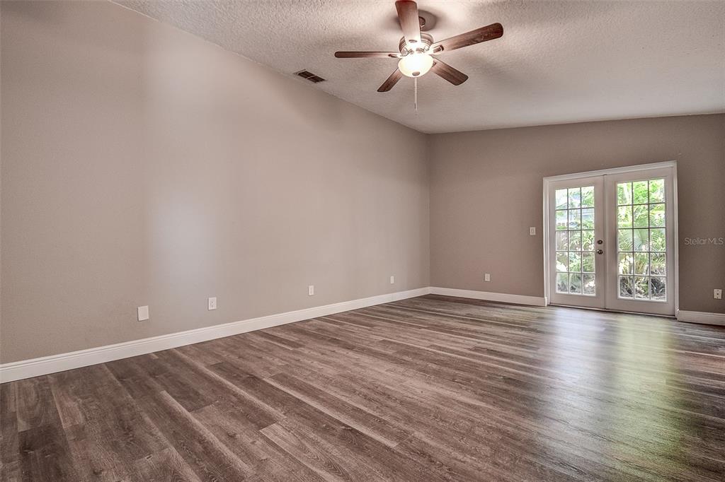 289 Whisper Lake Road Palm Harbor, FL 34683 - Photo 6 of 40 a view of an empty room with a window and wooden floor