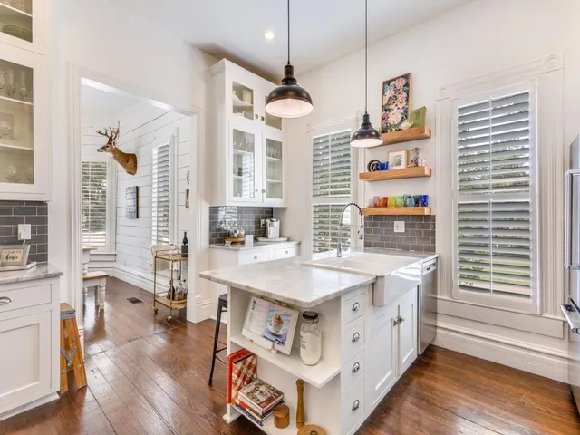 a kitchen with stainless steel appliances granite countertop a stove a refrigerator a kitchen island a stove and a wooden floors