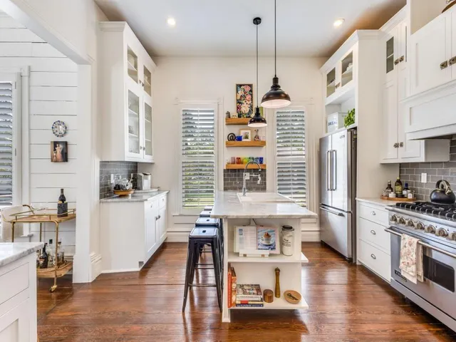 a kitchen with granite countertop a table chairs refrigerator and microwave