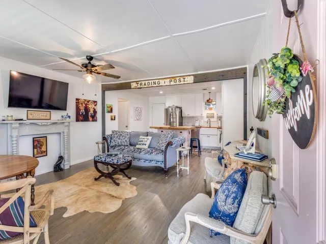 a kitchen with stainless steel appliances granite countertop a sink a stove a refrigerator cabinets and chairs